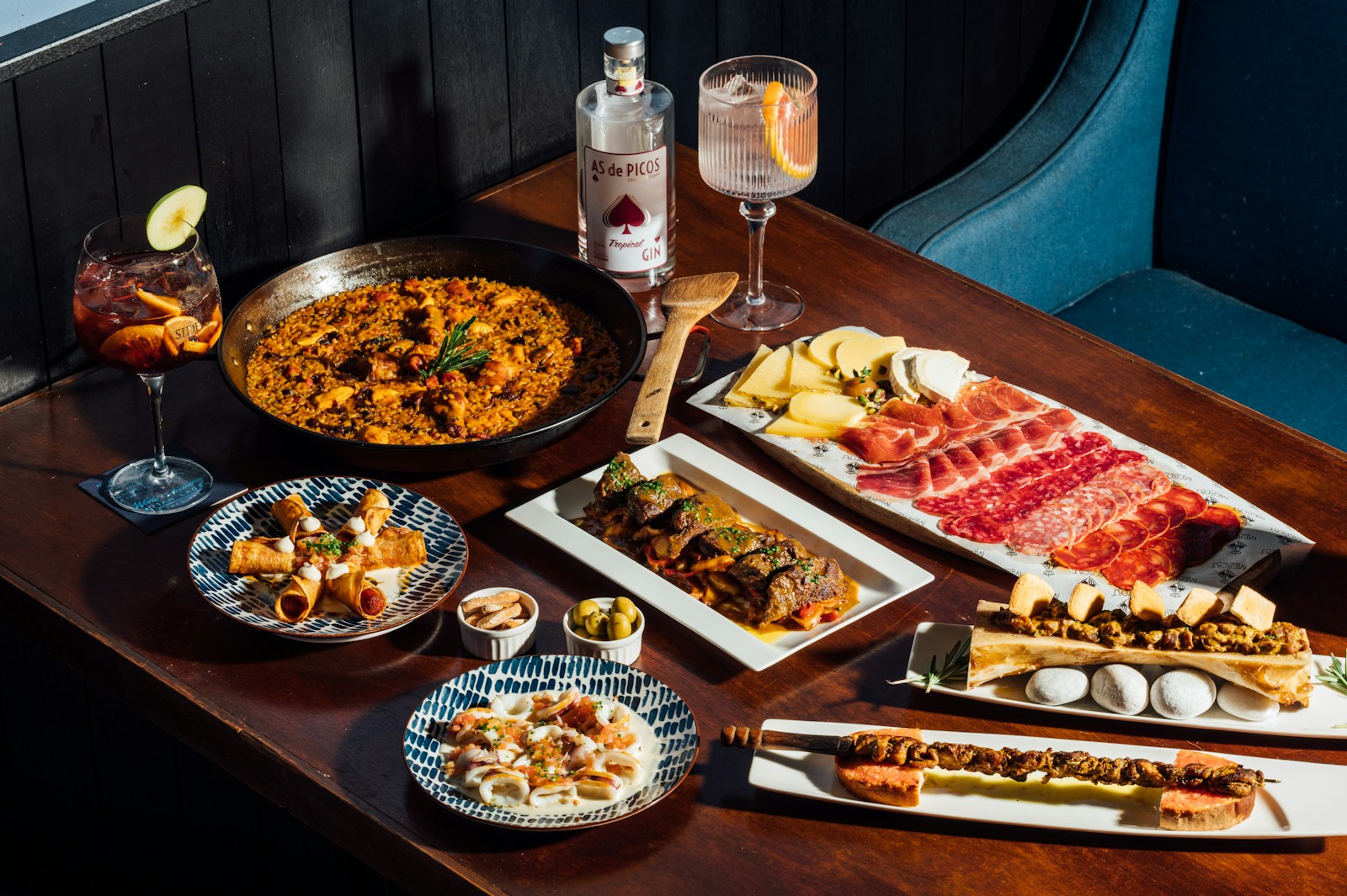 Fotografía de referencia: tabla de tapas y platos compartidos sobre una mesa de madera